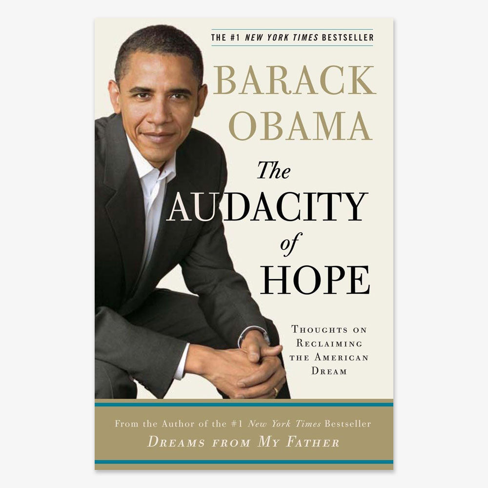 Book cover of The Audacity of Hope: Thoughts on Reclaiming the American Dream by Barack Obama, showing him seated and smiling in a suit against a light background, with title and subtitle highlighting his outlook on politics.