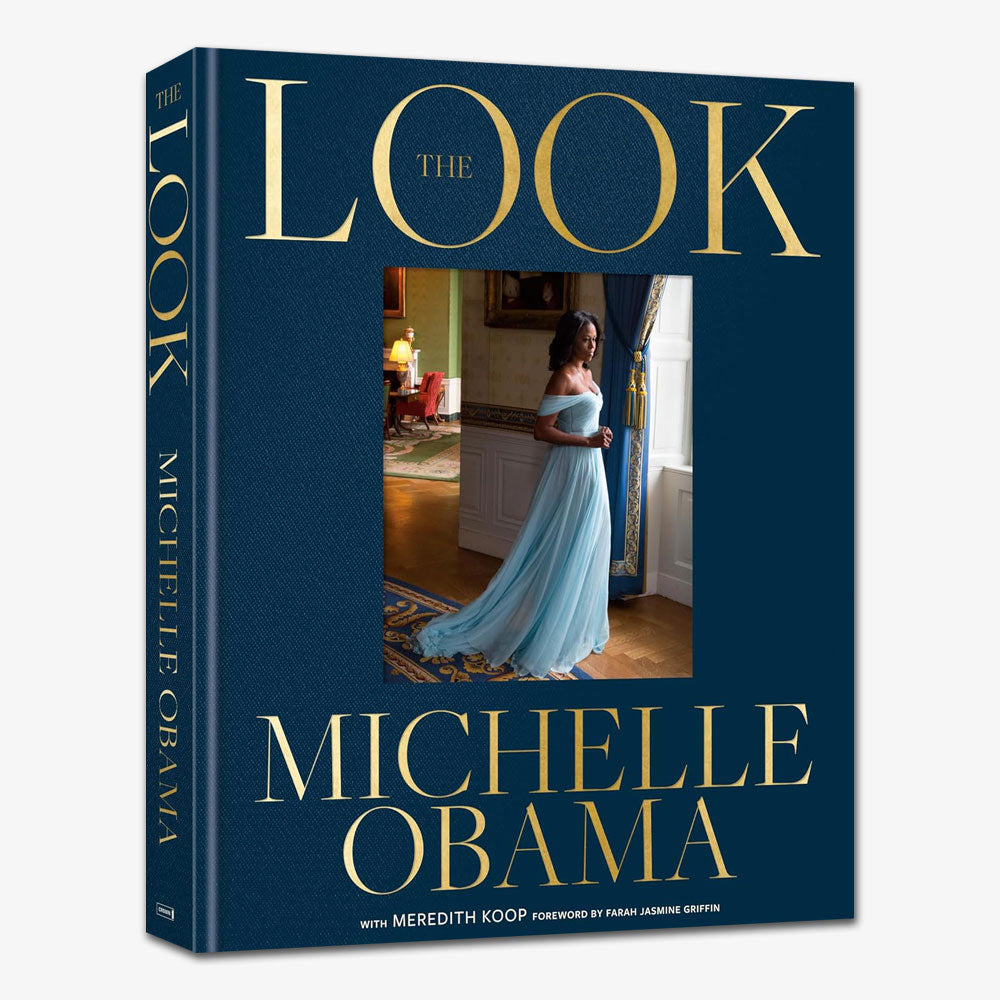 Book cover for "The Look, Michelle Obama," featuring a photo of Michelle Obama in an elegant light blue gown, highlighting her fashion evolution as she poses in a stately, gold-accented room.