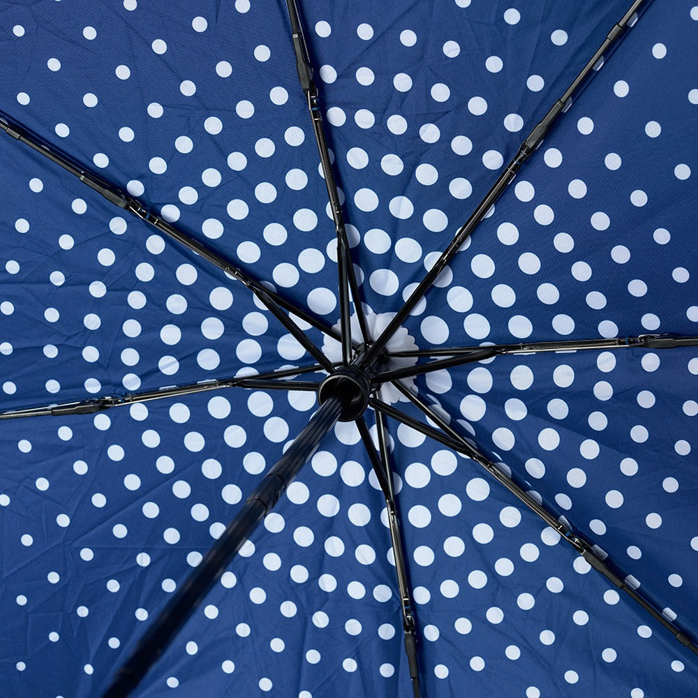 Close-up of the underside of the Obama Presidential Center Umbrella, featuring blue fabric with white circular polka dots and black metal spokes—an iconic accessory from Chicago’s South Side.