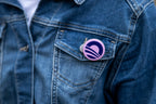 Close-up of a person wearing a denim jacket with an Obama Foundation Pin Set button, showing their support, pinned to the pocket.