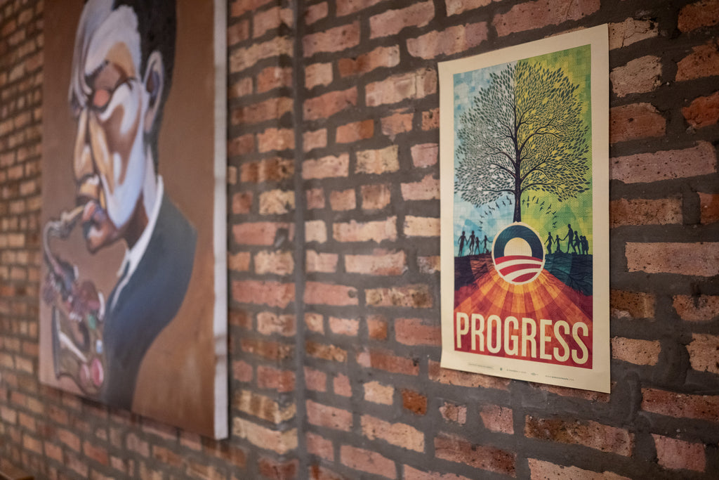 The Official Obama 2008 "Progress" Campaign Poster features a tree growing from the Obama O logo, silhouettes of people, and bold PROGRESS text—an iconic limited-edition print. A painting of a person smoking appears nearby.