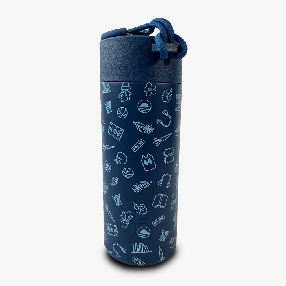 The Obama Presidential Center Hope Water Bottle, Navy, features a cylindrical design with light blue illustrations of books, basketballs, leaves, and light bulbs. It includes a matching blue lid with a looped strap inspired by Chicago's South Side community.