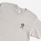 The Obama Foundation T-Shirt is a light gray crewneck tee with the rising sun logo and black text printed on the left chest, shown laid flat on a white background.